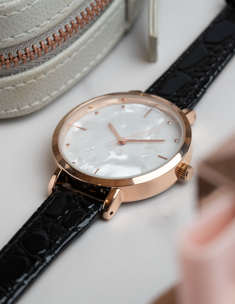 A close up image of a non branded ladies watch with mother of pear dial fitted with a premium alligator leather strap.