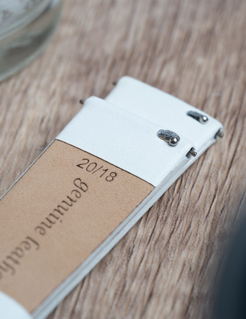 A close up image of a genuine leather quick release watch strap showing the quick release mechanism.