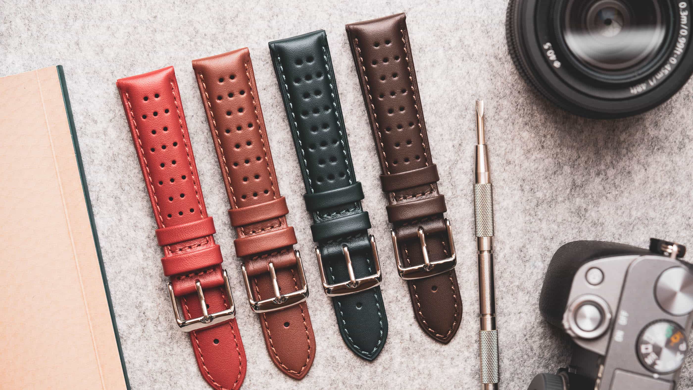 A selection of replacement watch straps with a spring bar tool.