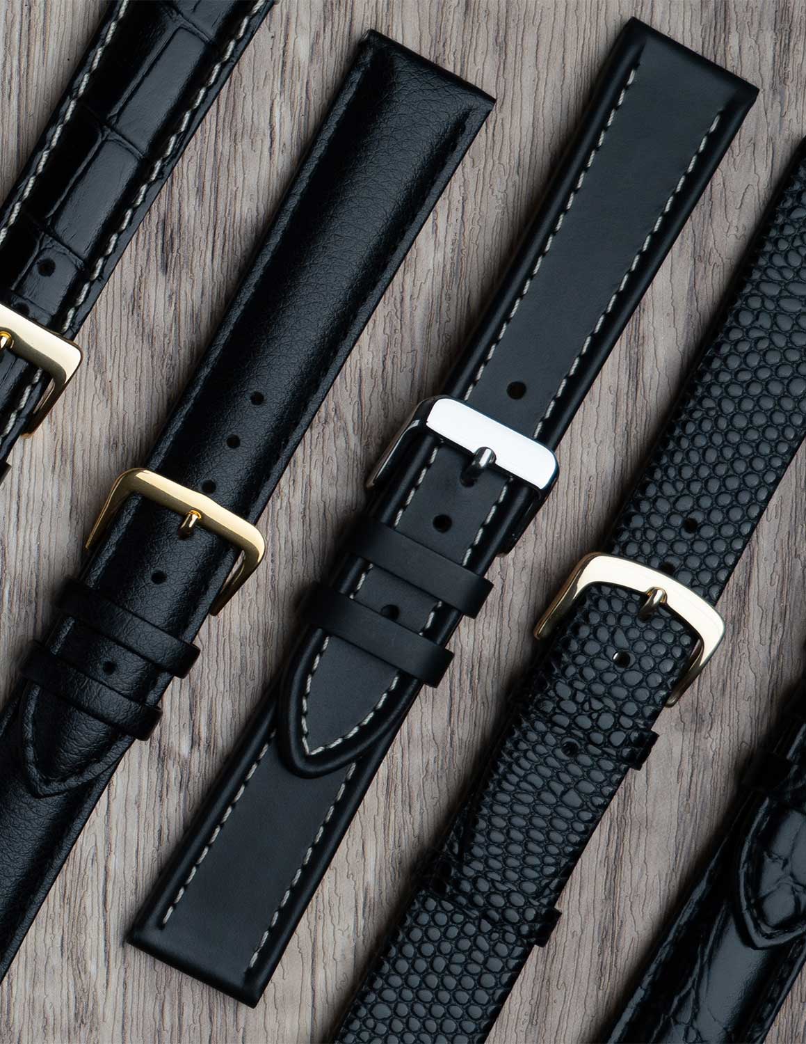 A selection of black watch straps showing the different grains of leather and styles.