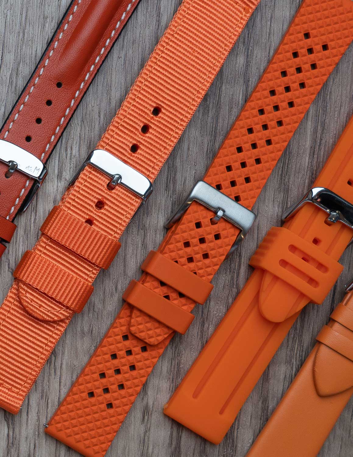 A selection of orange watch straps showing the different materials and styles.