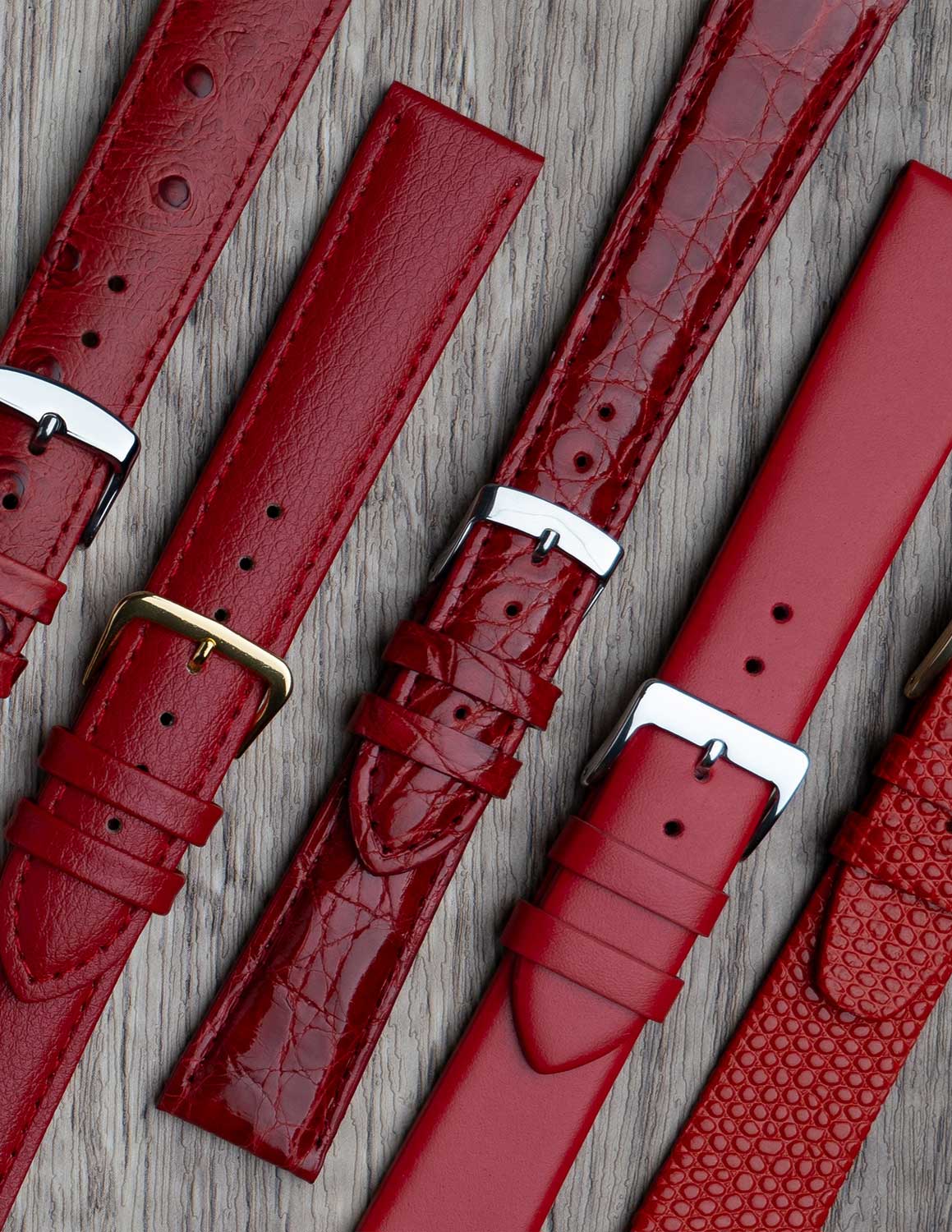 A selection of red watch straps showing the different grains of leather and styles.