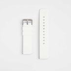 A white silicone watch strap with a silver buckle on a light background.